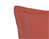 close up of the persimmon pillow with hand crocheted trim