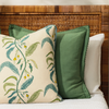 collection of verdant pillow and floral pillow on a bed with a cane bedhead