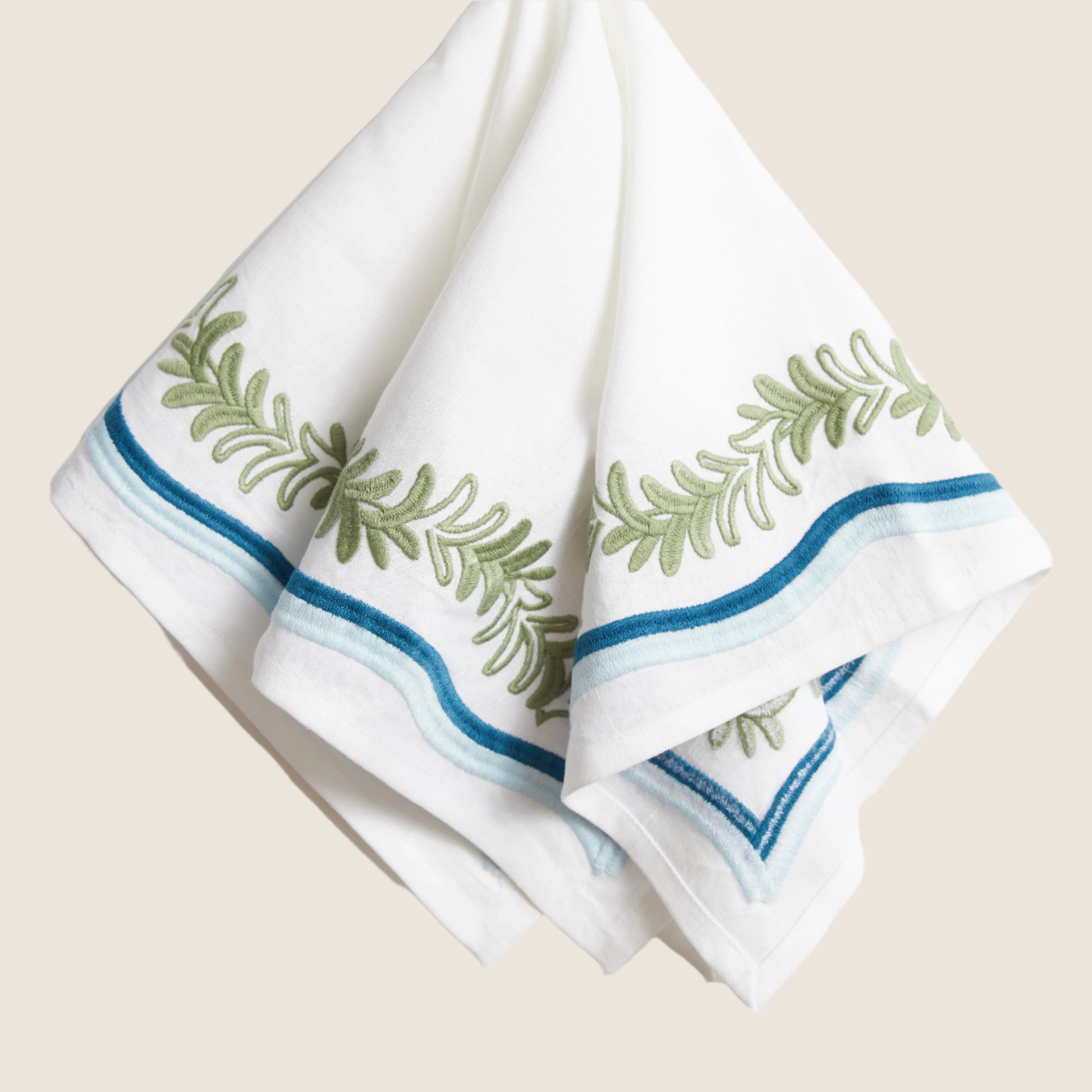 white napkin with green embroided pattern
