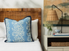 primrose lapis pillow with blue contrast trim styled on a bed with white bed linen