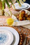 holly vine terracotta tablecloth styled with a fruit basket and glass of orange juice