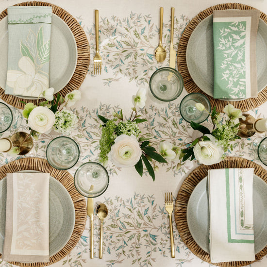 hollyvine green and blue tablecloth with place settings and bud vases